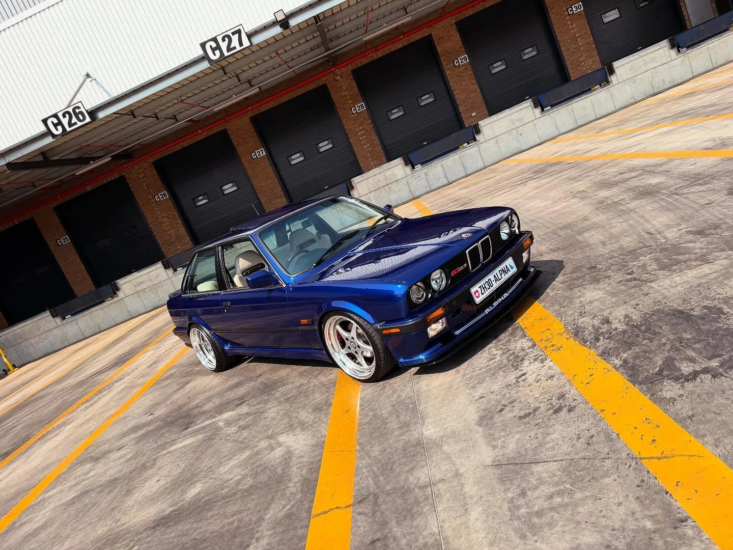 Classic blue BMW E30 outside in the sunlight