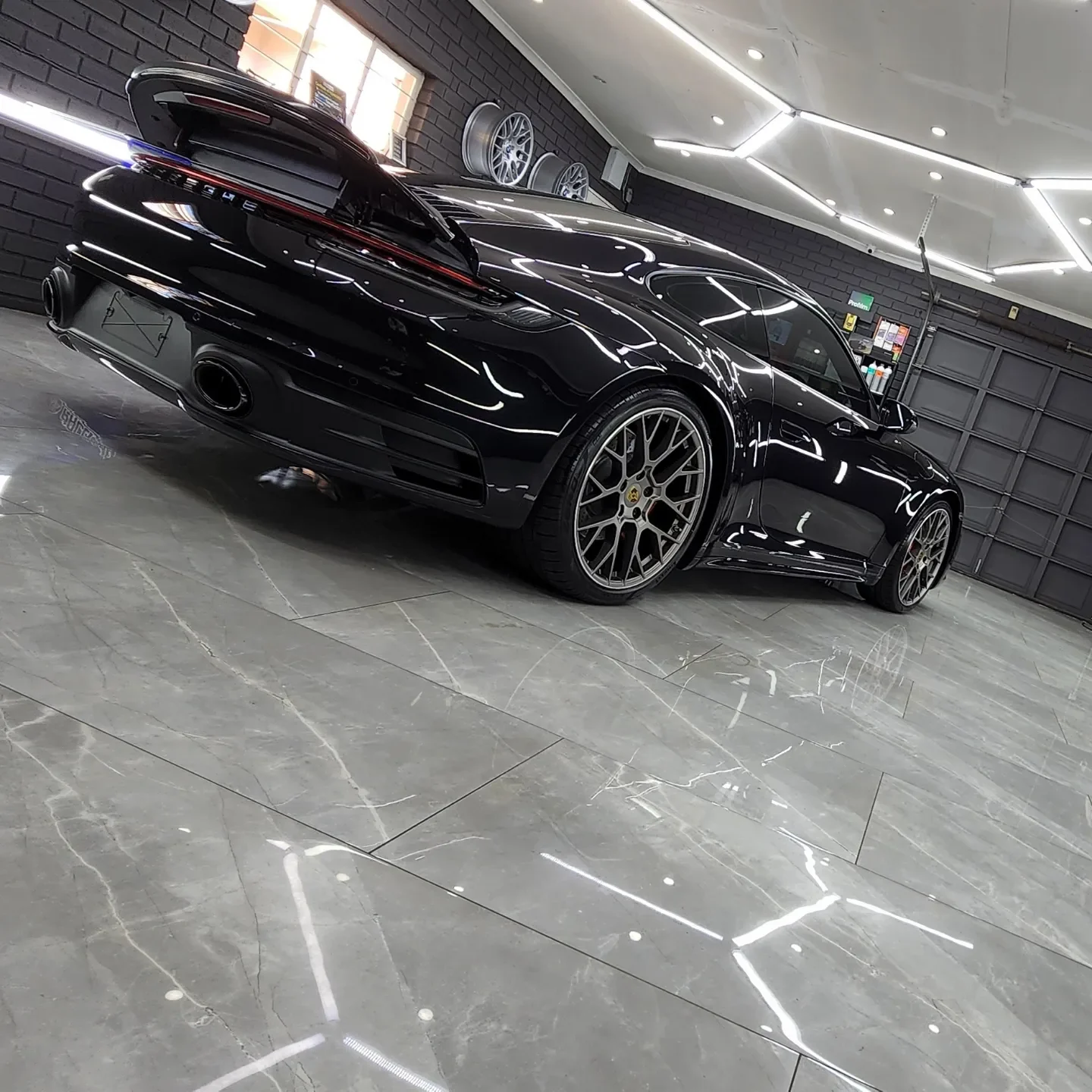 Black Porsche reflecting Auto Spa’s studio lighting